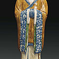 A large blue and sancai-glazed pottery figure of a court official, China, Tang dynasty (AD 618-907)