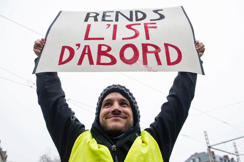 7796142495_un-gilet-jaune-brandissant-une-pancarte-sur-l-isf