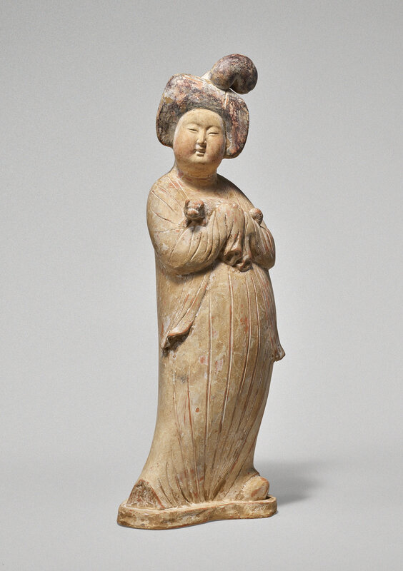 A rare and well-modeled painted pottery figure of a lady holding a dog, Tang dynasty (618-907)