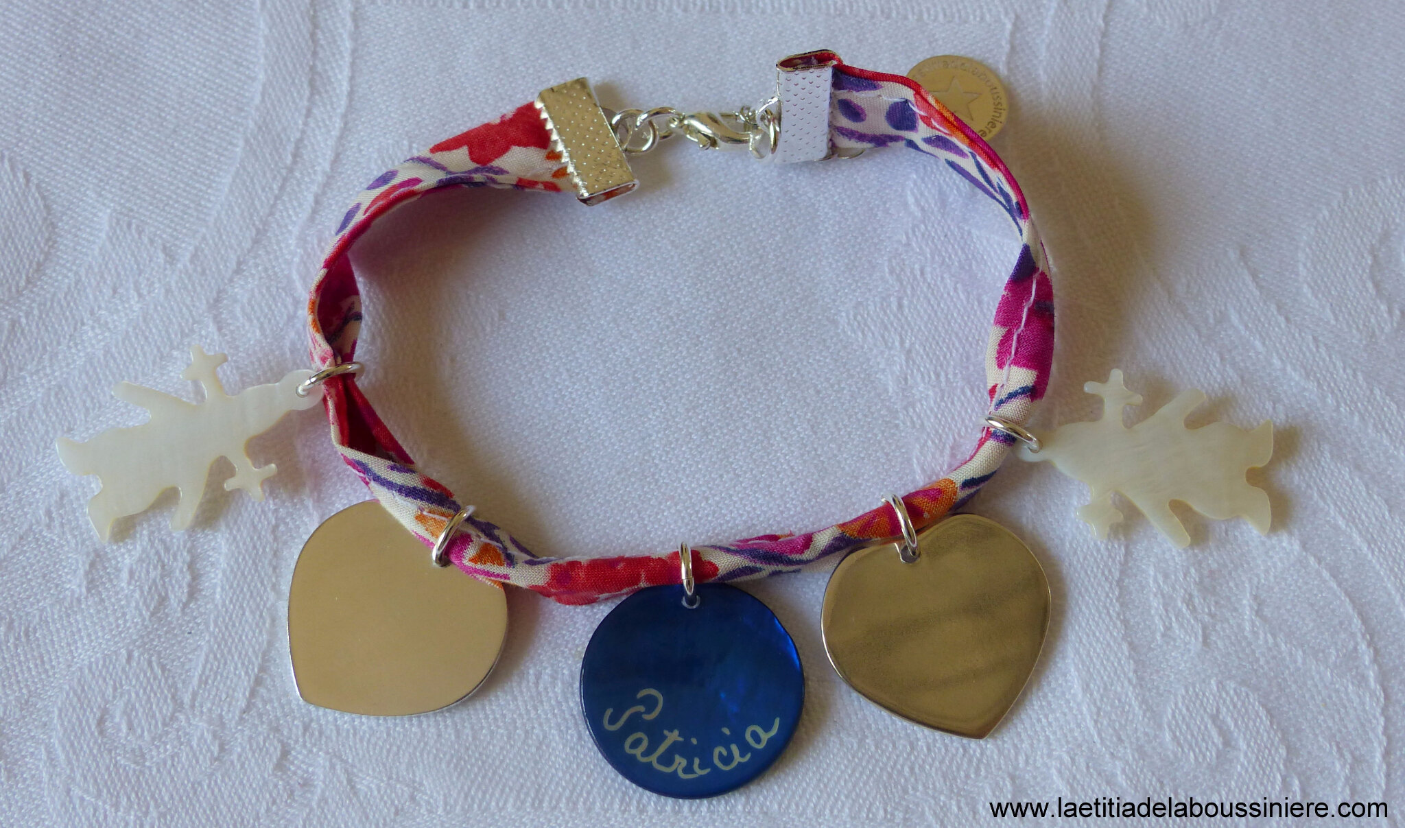 Bracelet sur ruban Liberty composé de 2 pendentifs fille en nacre, 2 coeurs en argent massif et un médaille en nacre gravée