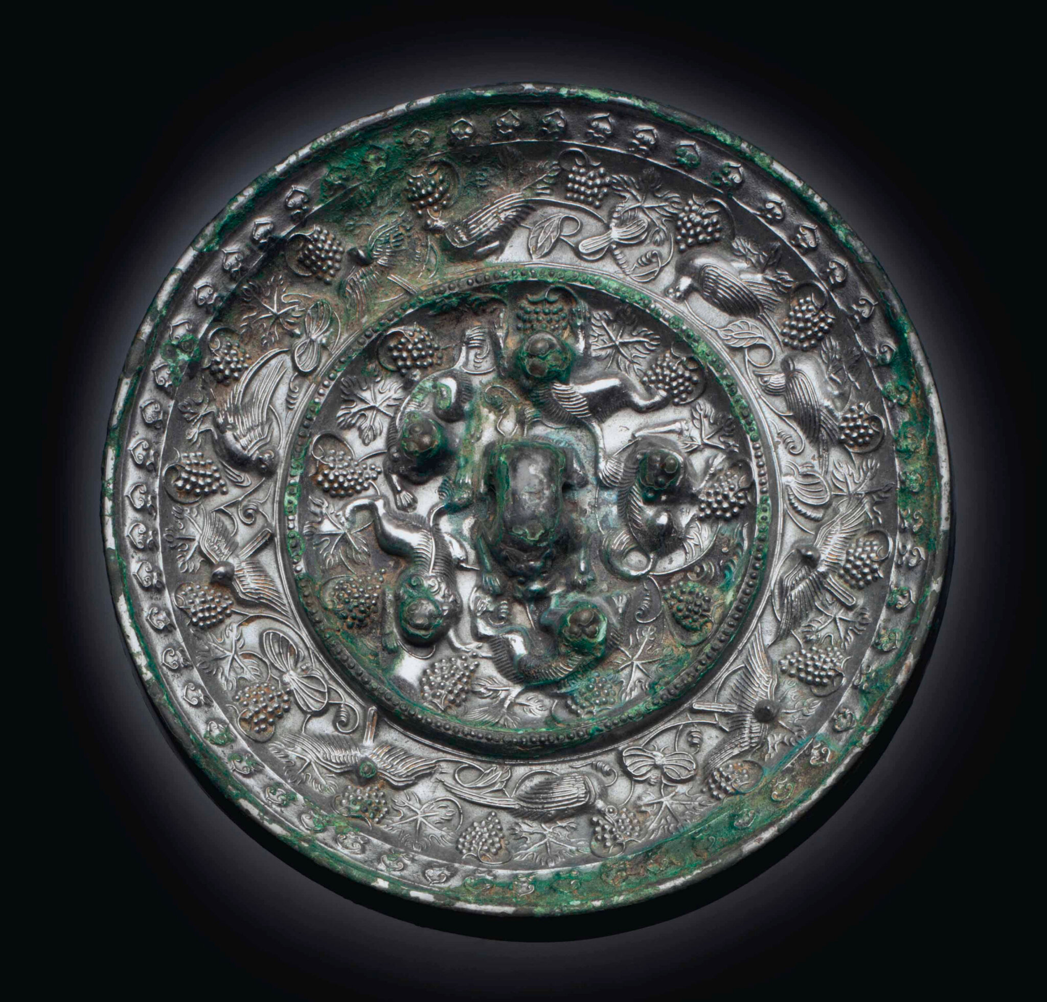 A silvery bronze 'Lion and Grapewine' mirror, Tang dynasty (AD 618-907)