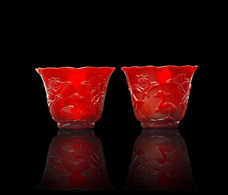 A pair of ruby-red c arved glass 'lotus' cups, Qianlong four-character wheel-cut marks and of the period