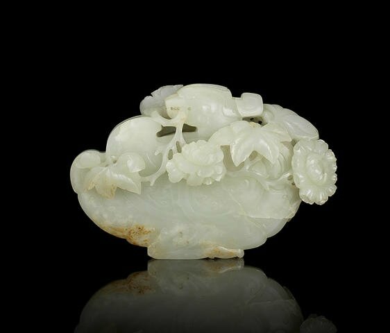 A rare pale green jade carving of a Mandarin duck and peony blossoms ...