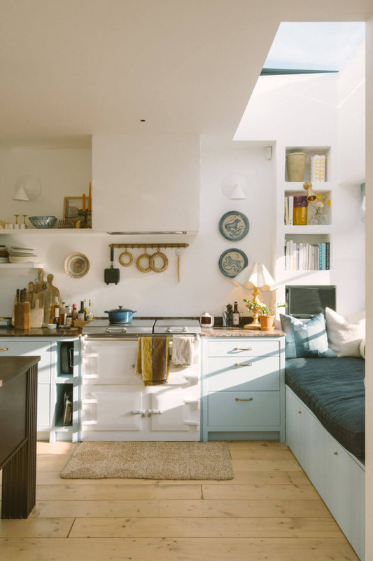 kitchen-window-seat-skylight-light-blue-cabinets-aga-stove-wooden-floor-nordroom-1000x1500