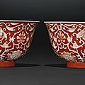 A fine pair of coral-ground reserve-decorated 'lotus' bowls, qianlong seal marks and period 